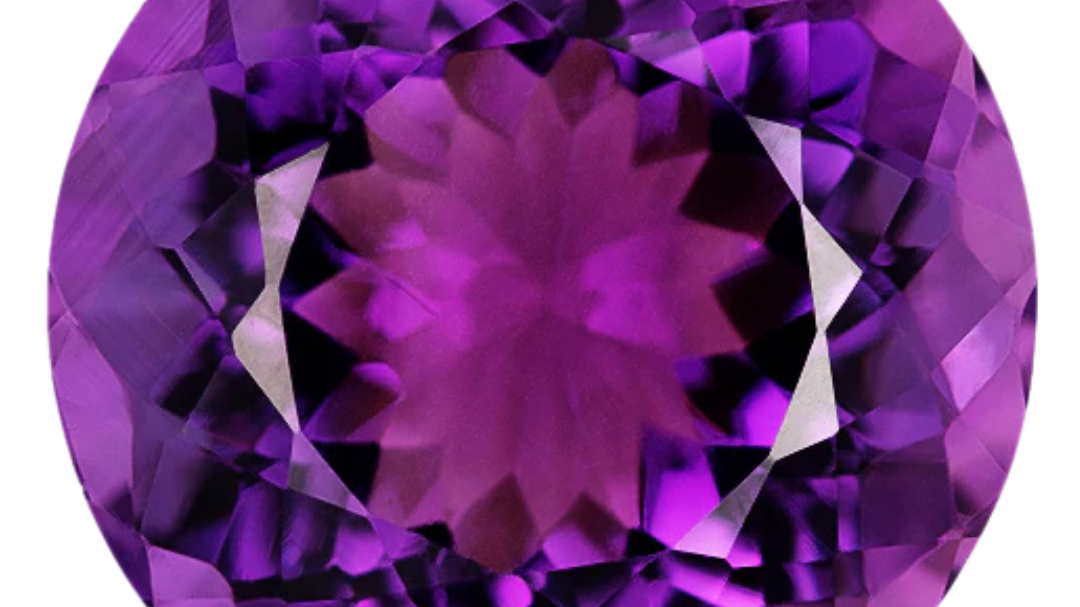 Round brilliant-cut amethyst in a vivid reddish purple with violet-purple flashes around the crown, photographed face-up on a pale gray background at Sapphire Row