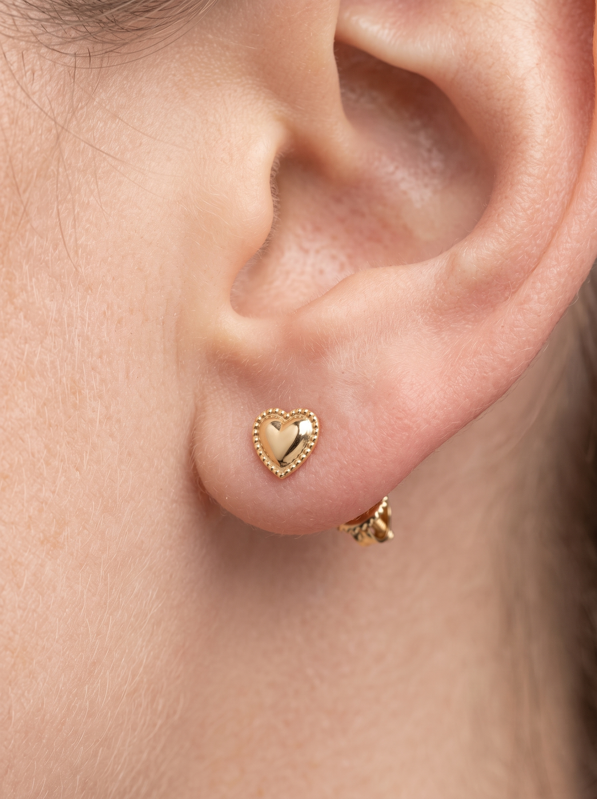 Gold Beaded Heart Stud Earrings in 14K Yellow Gold, shown close on the ear