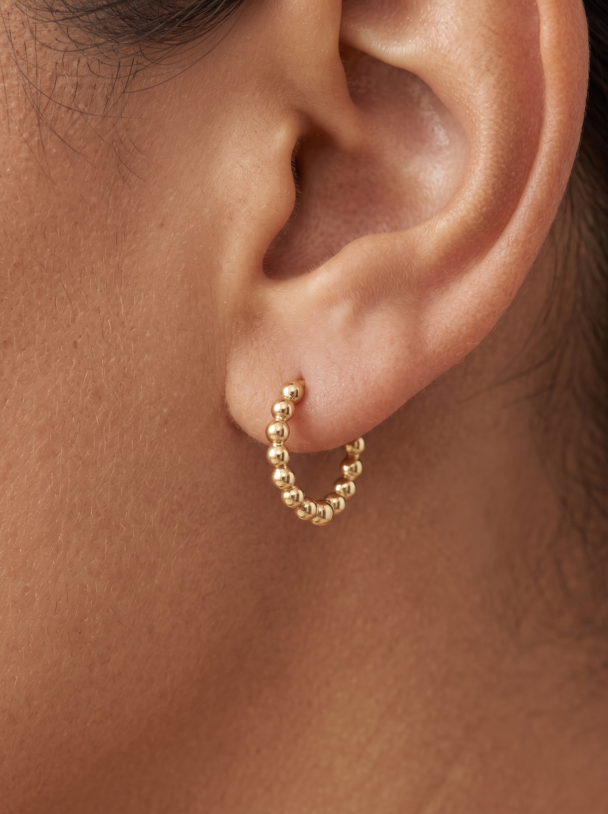 Gold Beaded Hoop Earrings in 14K Yellow Gold, shown close on the ear
