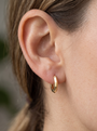 Gold Knife-Edge Huggie Earrings in 14K Yellow Gold, shown close on the ear