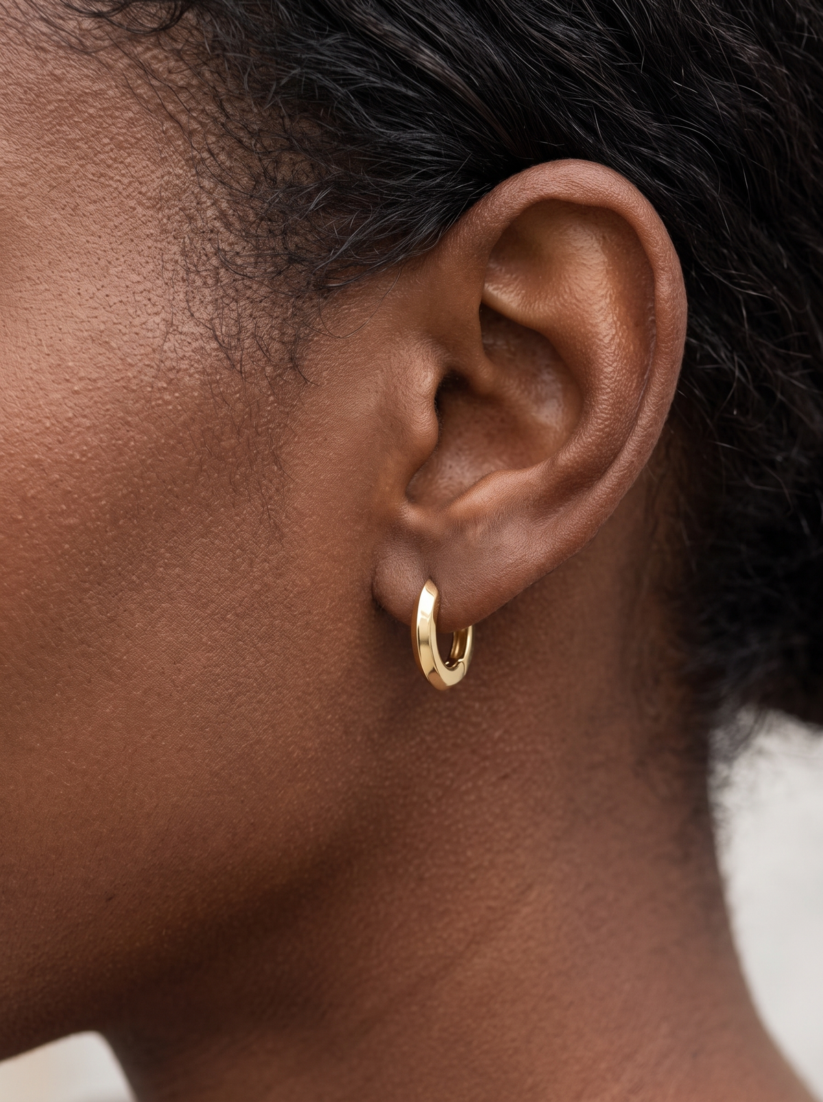 Gold Knife-Edge Huggie Earrings in 14K Yellow Gold, worn on the ear