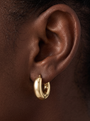 Gold Puffed Huggie Earrings in 14K Yellow Gold, shown close on the ear