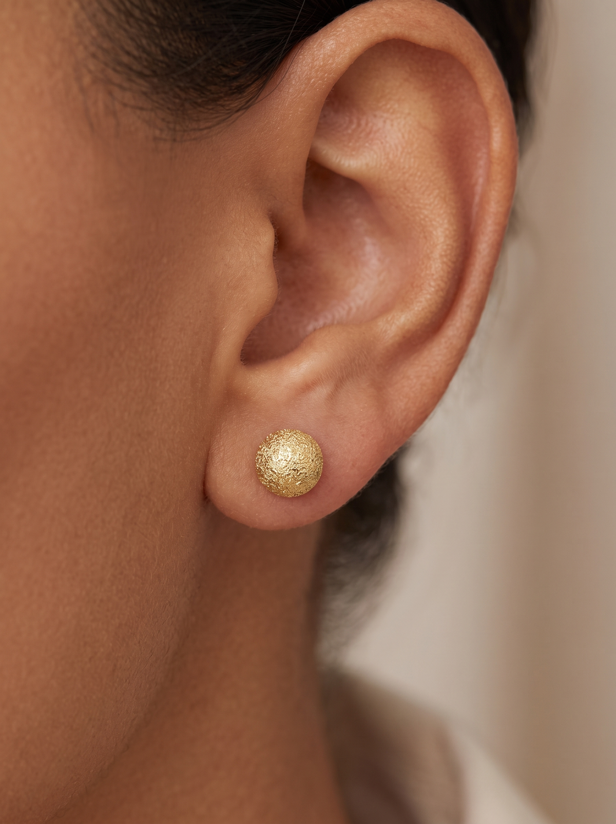 Gold Stardust Ball Stud Earrings in 14K Yellow Gold, shown close on the ear