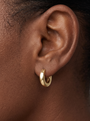 Gold Thick Huggie Earrings in 10K Yellow Gold, shown close on the ear