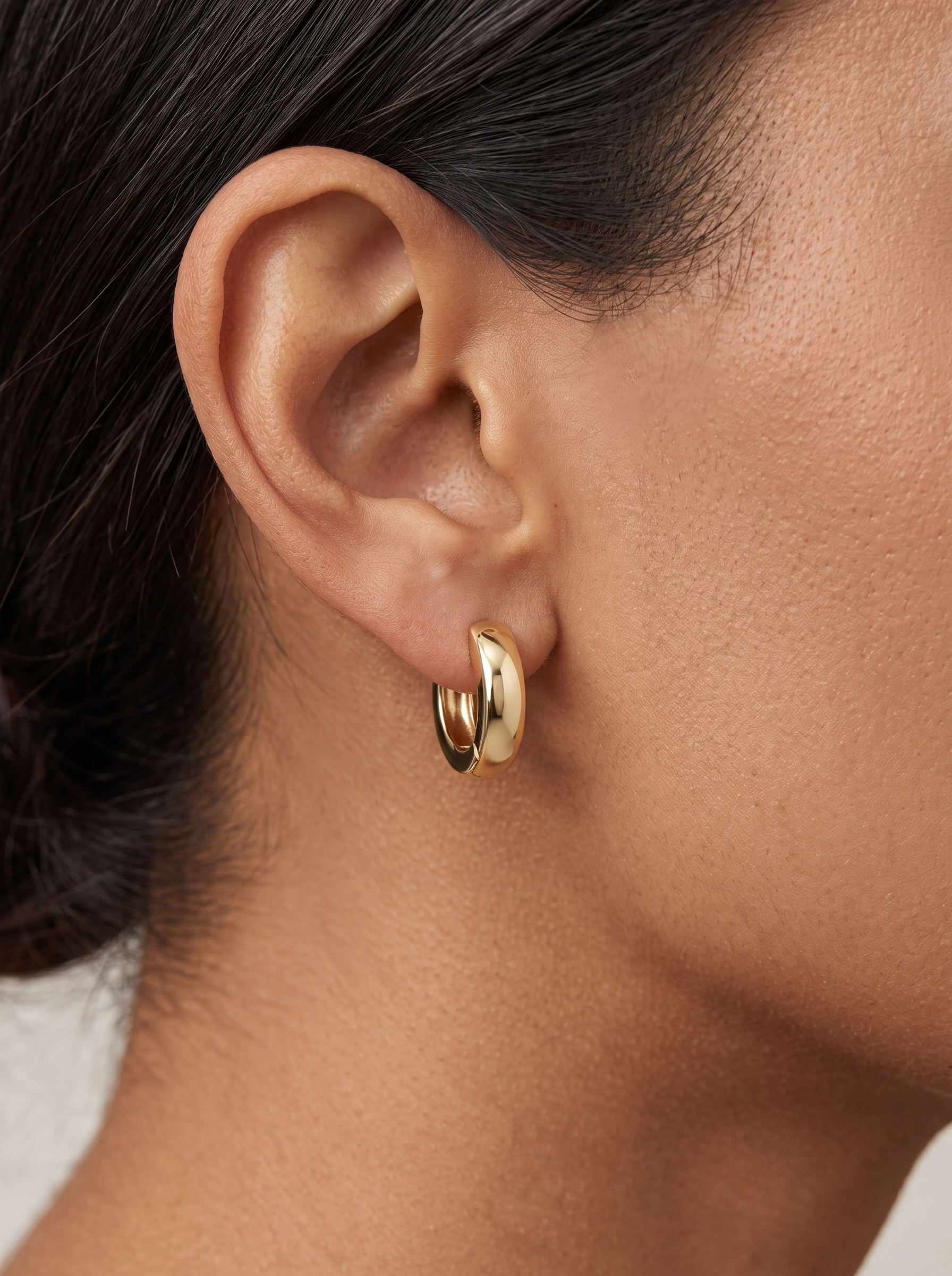 Gold Thick Huggie Earrings in 10K Yellow Gold, worn on the ear