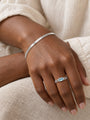 Natural Sky Blue Topaz Chain Ring in 14K White Gold, shown close on the gently curled hand with a herringbone bracelet