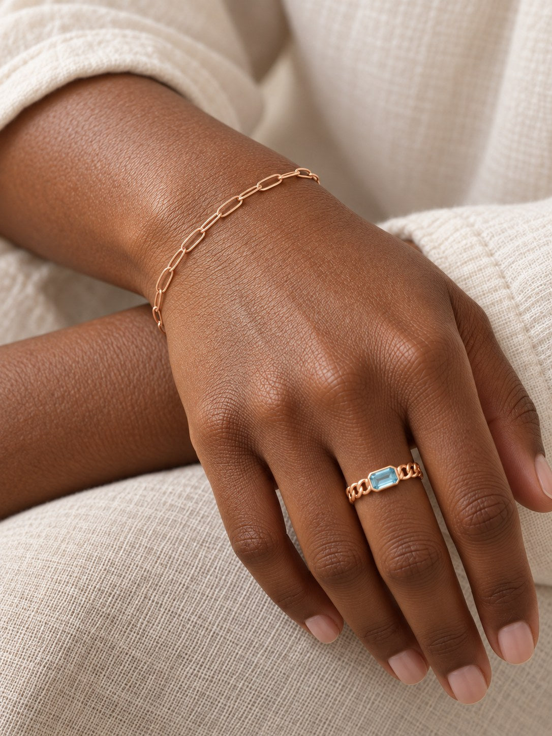 Natural Sky Blue Topaz Chain Ring in 14K Rose Gold, shown close on the gently curled hand with a petite paperclip bracelet