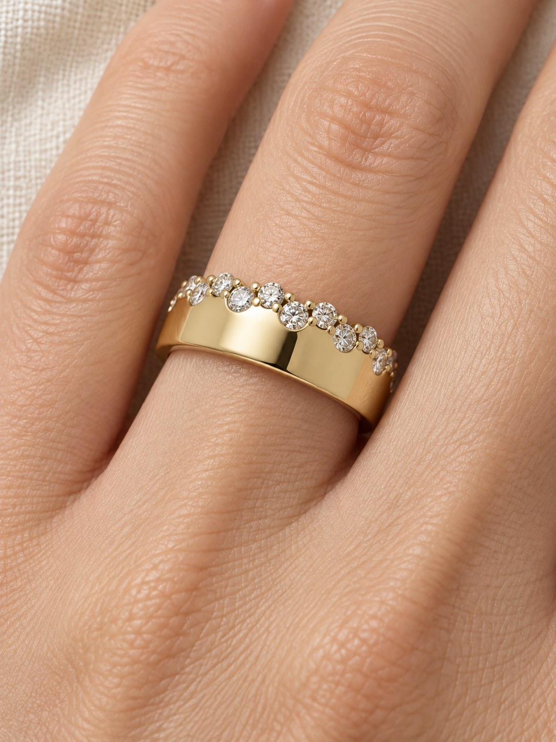 Natural Diamond Cigar Band in 14K Yellow Gold, worn on the finger, close detail of the staggered diamond edge