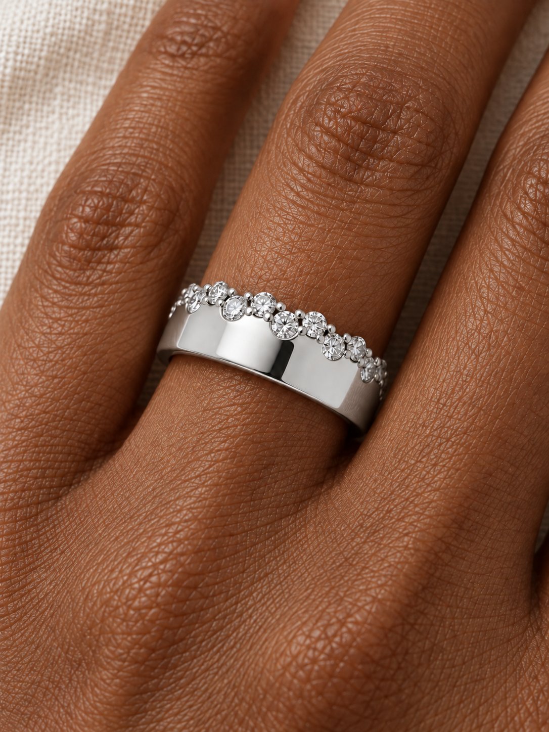 Natural Diamond Cigar Band in 14K White Gold, shown close on the finger, polished face beneath an alternating diamond edge