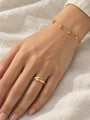 Gold Bead Station Bracelet in 14K Yellow Gold, worn on the wrist with a domed bypass ring