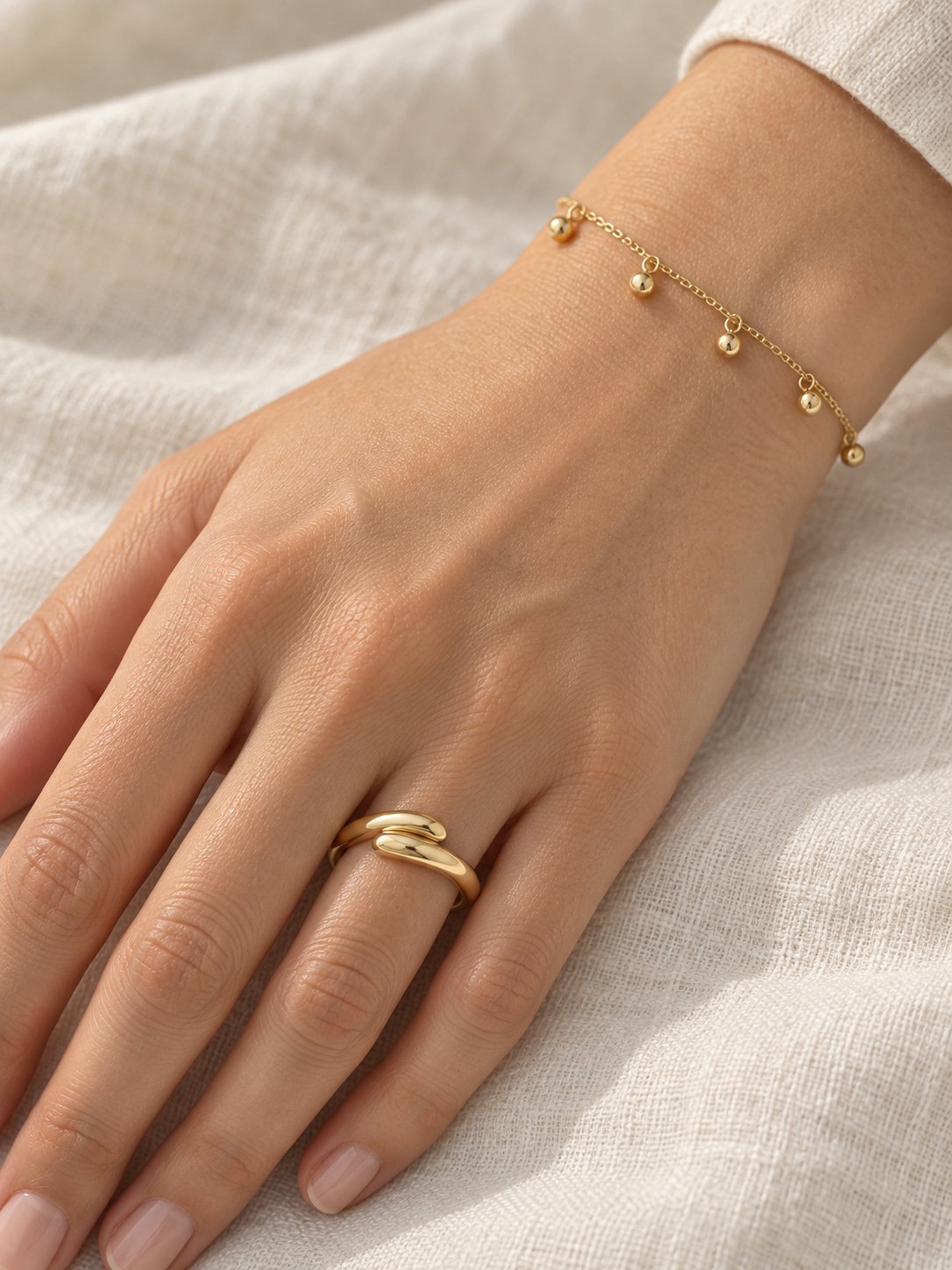 Gold Bead Station Bracelet in 14K Yellow Gold, worn on the wrist with a domed bypass ring