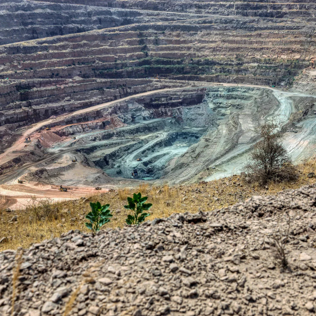 Open-pit gemstone mine with tiered stone layers and excavation vehicles
