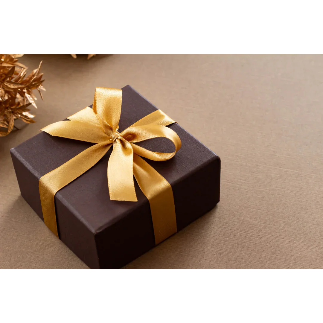 Gift box with gold ribbon on brown background, luxury jewelry packaging
