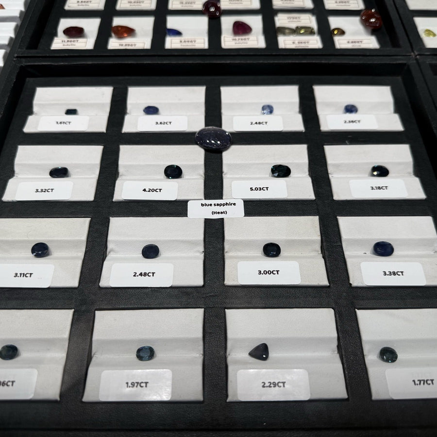 Collection tray of certified loose gemstones with carat labels