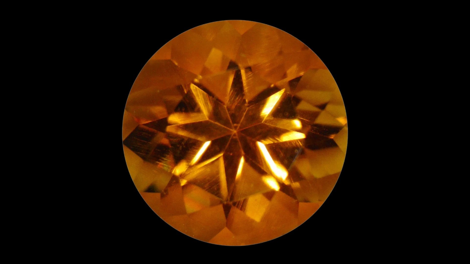 Round golden citrine gemstone on a black background