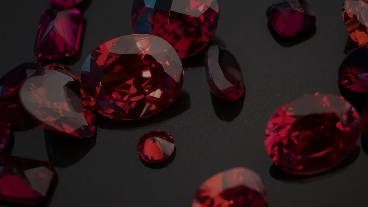 Scattered red garnet gemstones on a dark background