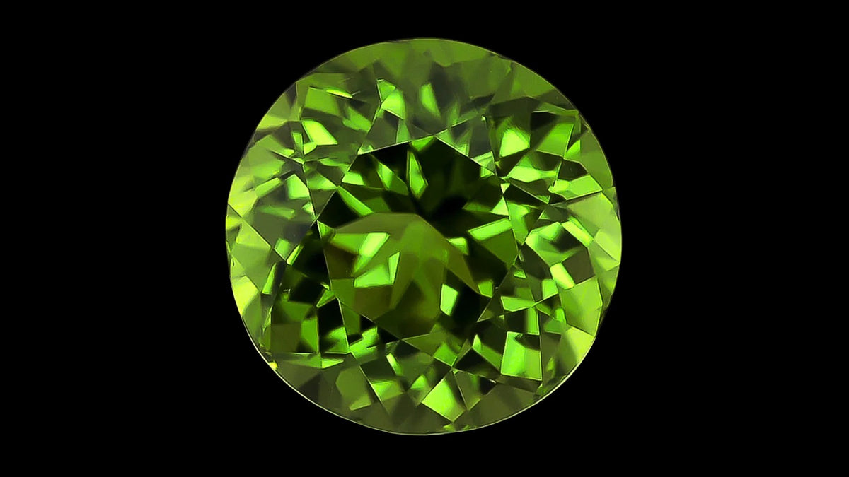 Round lime-green peridot gemstone on a black background