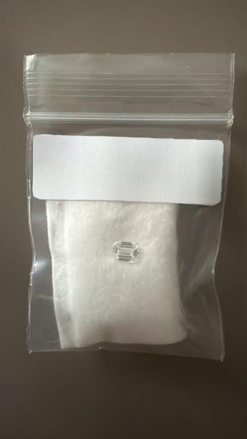 The emerald-cut diamond in its bag
