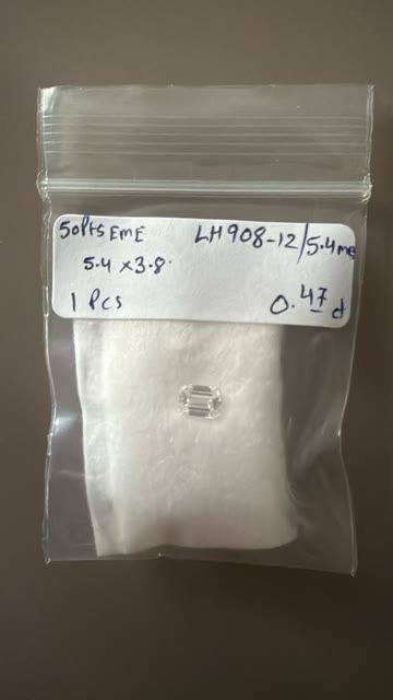 The emerald-cut diamond in its labeled bag